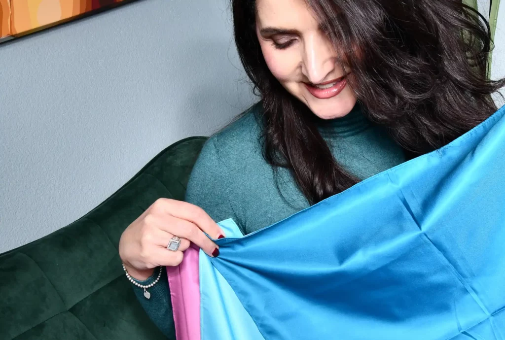 Morena Tigano mit farbigen Stoffbahnen. Vordergrundbild von Morena Tigano, lächelnd mit Tüchern für die Farbanalyse.