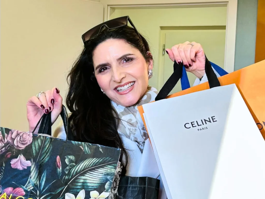 Personal Shopping Service Die lächelnde Morena Tigano hält Einkaufstaschen nach einer Personal Shopping Session in den Händen.